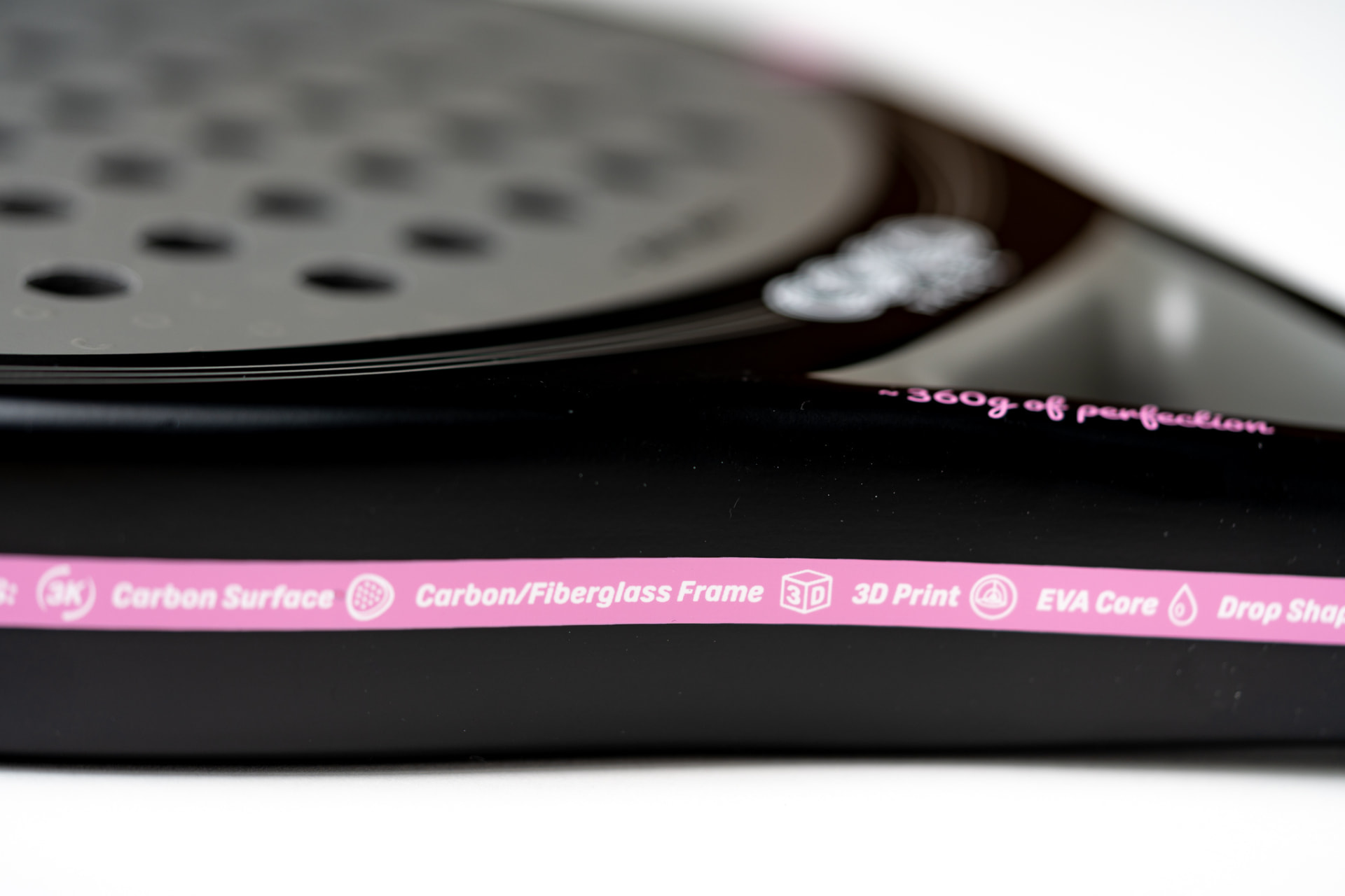 Close-up of a black COCO racket frame showing carbon surface, EVA core and 3D print labels